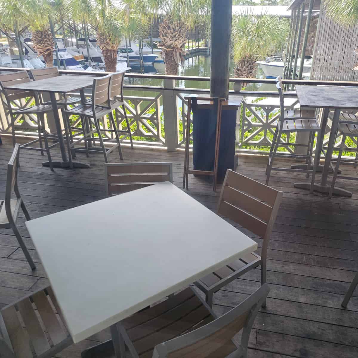 outdoor deck seating with tables and chairs overlooking the marina