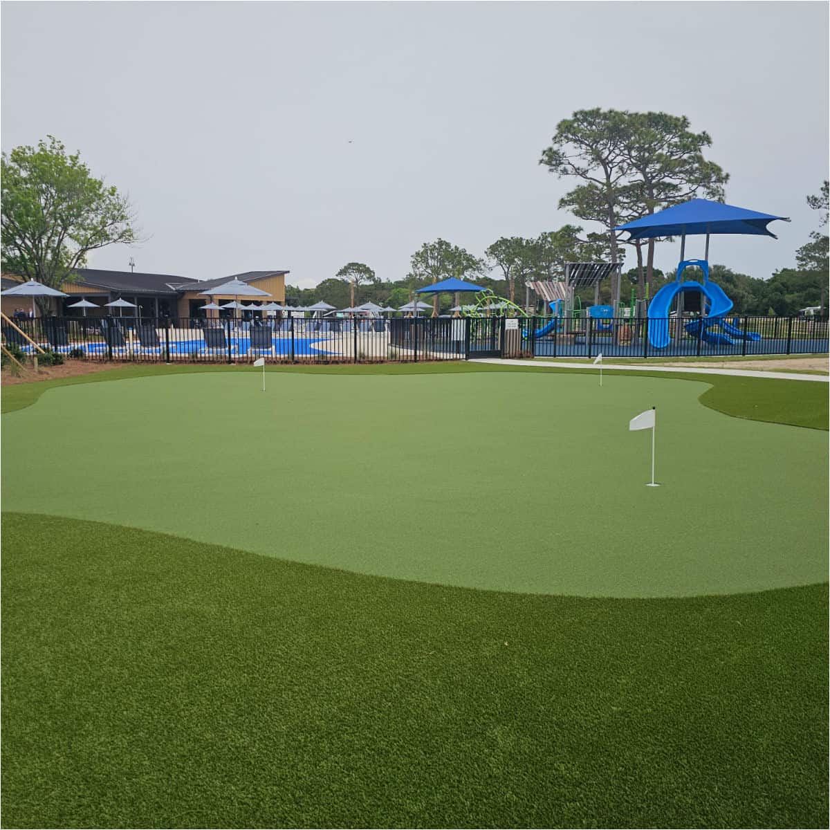 mini golf course with a kids playground and pool behind it