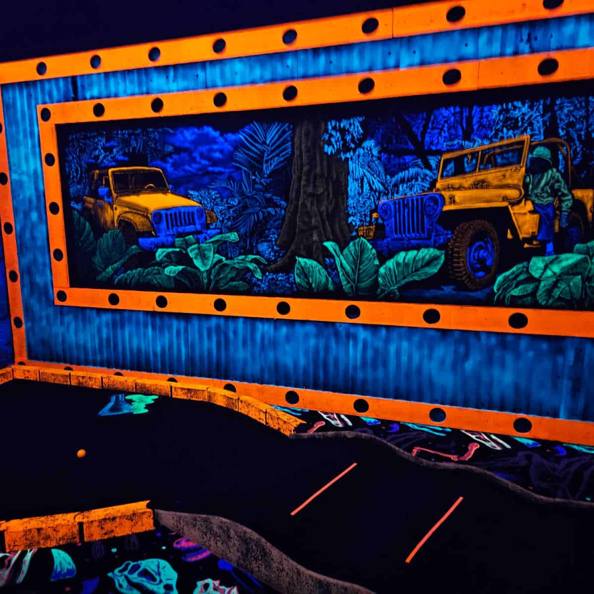 neon light mini golf with two jeeps in a jungle seen over the mini golf hole